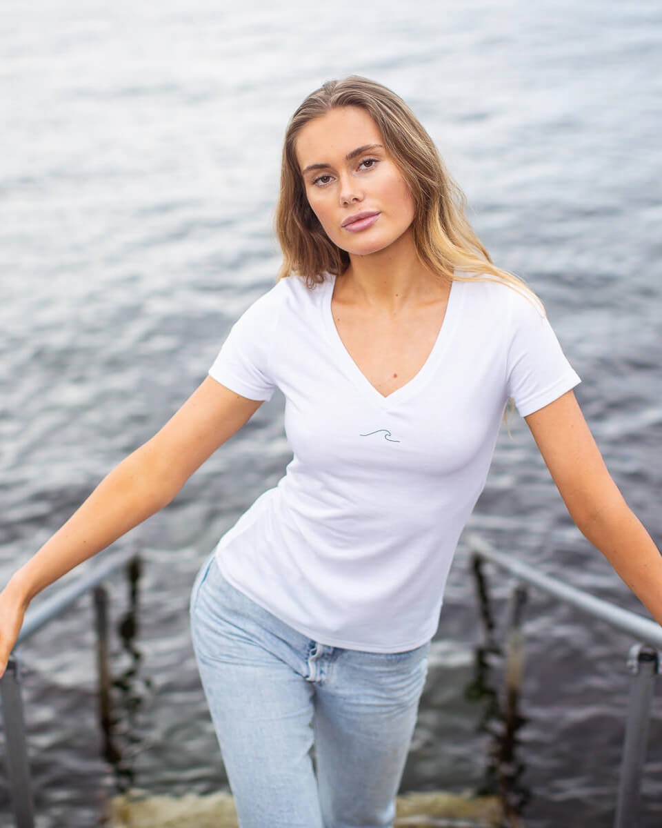 Model posing in eco-friendly Oceanness t-shirt with wave in Arctic White