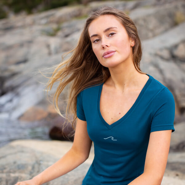 Woman sitting outside in Eco Oceanness Ocean Green T-shirt