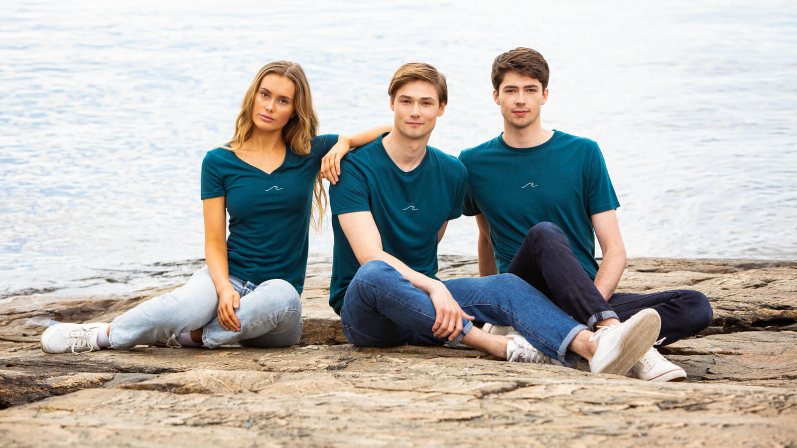 Models posing by the ocean in Eco Oceanness T-Shirts in Ocean Green