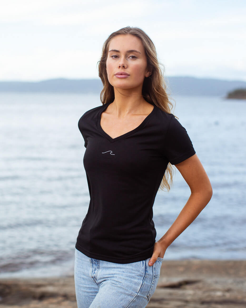 Model posing in eco-friendly Oceanness t-shirt with wave in Midnight Black