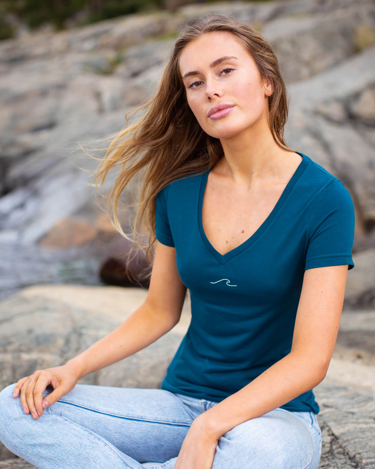 Model posing in eco-friendly Oceanness t-shirt with wave in Ocean Green